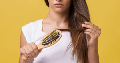 Woman hand holding her long hair with looking at damaged splitting ends of hair care problems.